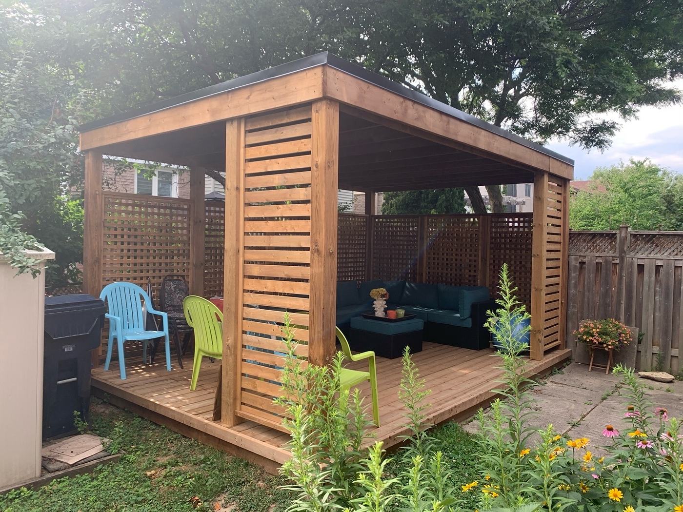 Freestanding cedar gazebo with lattice privacy screens and lounge seating